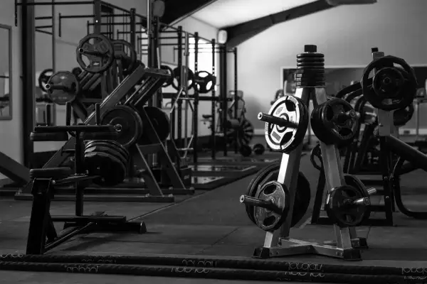 Máquinas de gimnasio con pesas y barras en un gimnasio.